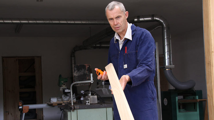 Photo of of a person estimating the length of a piece of timber.