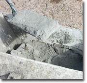 Photograph of a spade and concrete.