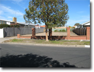 Photo of a street and driveway to a block of land.