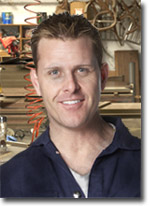 Photo of a tradesperson standing in front of a workbench with compressed air hoses.