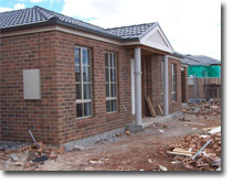 Photo of a brick house under construction. 