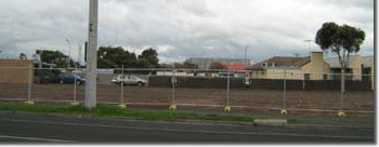 Photo of an empty site with a fence around it. 