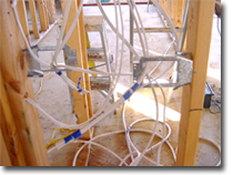 Photo of a wall frame with plumbing roughed in.