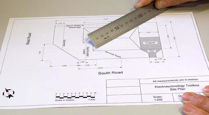 Photo showing measuring diagonally with a ruler from a wall corner to a wall corner on a site plan