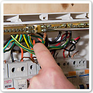 Photo showing a worker placing wire in a switchboard