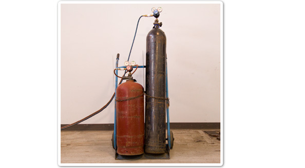 Photo of welding equipment that uses a red gas bottle and a black gas bottle