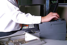 Person reaching across to the printer