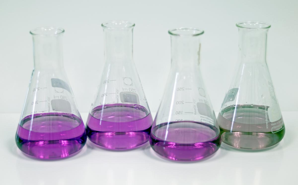 Beakers of purple liquid in different concentrations - darker and lighter liquids